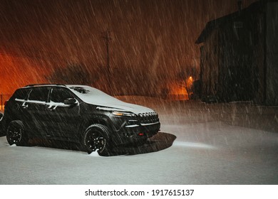 Austin, Texas - Feb 15, 2021: Night View Of The Blizzard In Austin, Texas. The Snow Is Blowing Strongly. The Road, The Cars And The Buildings Are Covered By Snow.