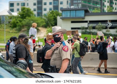 Austin, Texas / USA - May 30, 2020: Texas Department Of Public Safety Officer Watches Protesters Demonstrating Against Police Brutality On Interstate 35 In Downtown Austin, TX. 