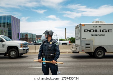 Austin, Texas / USA - May 30, 2020: A Police Officer Watches As Protesters Demonstrating Against Police Brutality Overtake Interstate 35 In Downtown Austin, TX. 