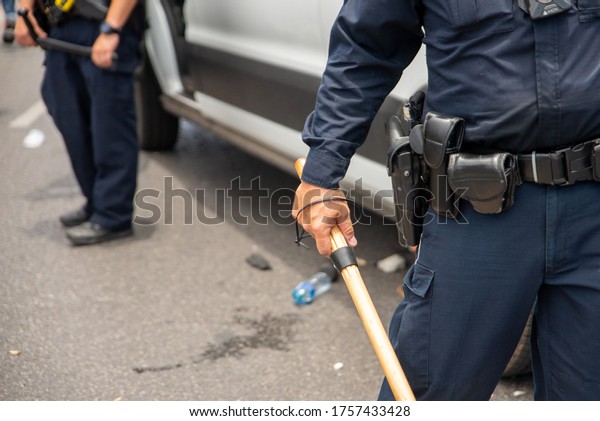 Austin, Texas / USA - May 30, 2020:\
A police officer watches as protesters demonstrating against police\
brutality overtake Interstate 35 in Downtown Austin, TX.\
