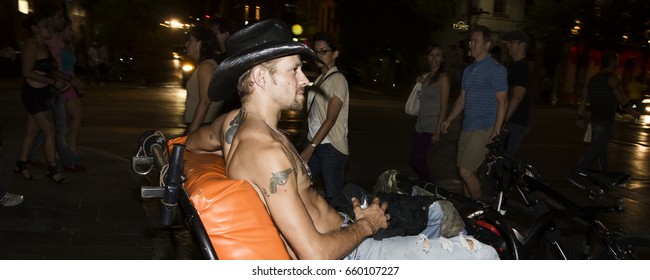 AUSTIN, TEXAS/USA - SEPTEMBER 2012: Pedicab Driver With Cowboy Hat Relaxing While Waiting For Clients On Six Street, The Night Life Hub In Austin, Texas