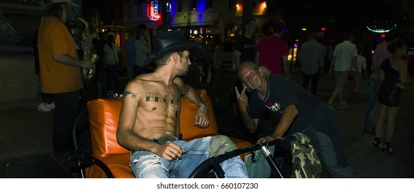 AUSTIN, TEXAS/USA - SEPTEMBER 2012: Pedicab Driver With Cowboy Hat Relaxing While Waiting For Clients On Six Street, The Night Life Hub In Austin, Texas