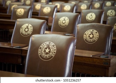Austin, TEXAS/USA - September 9, 2017: Rows of leather seats, with gold embossed The State of Texas and Lone Star seal, in the  House of Representatives chambers at the capitol building