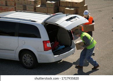 Austin, TX / USA - Apr. 15, 2020: A Male And A Female Volunteer Distribute Emergency Food Aid From The Central Texas Food Bank To People In Need At A High School Parking Lot.