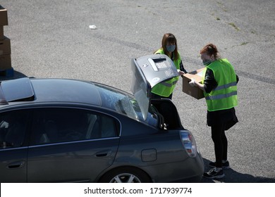 Austin, TX / USA - Apr. 15, 2020: Two Female Volunteers Distribute Emergency Food Aid From The Central Texas Food Bank To People In Need At A High School Parking Lot.