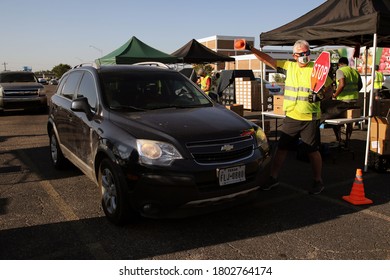 Austin, TX / USA - Aug. 20, 2020: A Male Volunteer Releases An SUV In The Parking Lot Of A High School After It Received Emergency Food Aid From The Central Texas Food Bank.