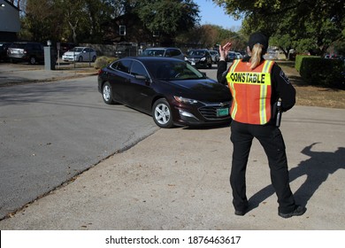 Austin, TX USA - Dec. 12, 2020: A Female Constable Directs A Line Of Cars Waiting To Receive Free Diapers From The Austin Diaper Bank.