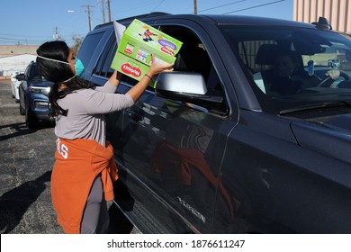 Austin, TX USA - Dec. 12, 2020:  Two Weeks Before Christmas, A Female Volunteer For The Austin Diaper Bank Hands A Box Of Free Diapers To A Woman Waiting In A Line Of Cars.