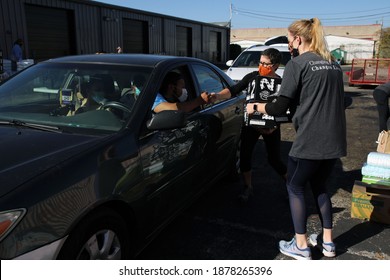 Austin, TX USA - Dec. 12, 2020:  Two Weeks Before Christmas, Two Female Volunteers For The Austin Diaper Bank Give Boxes Of Free Diapers To A Family At A Drive Thru Event.