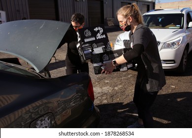 Austin, TX USA - Dec. 12, 2020:  Two Weeks Before Christmas, Two Female Volunteers For The Austin Diaper Bank Give Boxes Of Free Diapers To A Family In Need At A Drive Thru Event.