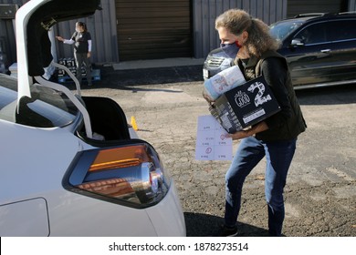 Austin, TX USA - Dec. 12, 2020:  Two Weeks Before Christmas, A Female Volunteer For The Austin Diaper Bank Gives Boxes Of Free Diapers To A Family In Need At A Drive Thru Event.