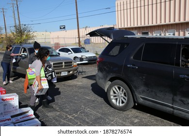 Austin, TX USA - Dec. 12, 2020:  Two Weeks Before Christmas, A Female Volunteer For The Austin Diaper Bank Carries Boxes Of Free Diapers To A Family In Need At A Drive Thru Event.