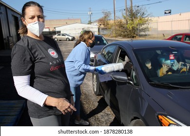 Austin, TX USA - Dec. 12, 2020:  Two Weeks Before Christmas, An African American Female Volunteer For The Austin Diaper Bank Gives A Package Of Free Diapers To A Family In Need At A Drive Thru Event.