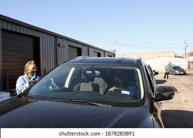 Austin, TX USA - Dec. 12, 2020:  Two Weeks Before Christmas, An African American Female Volunteer For The Austin Diaper Bank Confirms The Number Of Free Diapers Needed At A Drive Thru Event.