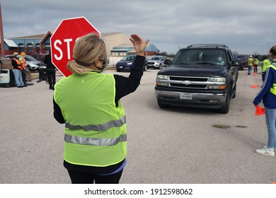 Austin, TX USA - Feb. 4, 2021: A Female Volunteer Directs Traffic At A Distribution Of Emergency Food Aid By The Central Texas Food Bank At The Expo Center.