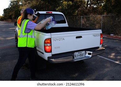 Austin, TX, USA - Feb. 8, 2022:  A Young Female  Volunteer Distributes Free Bottled Water At A High School Football Stadium After A Water Treatment Plant Mishap Caused A City Wide Boil Water Notice.