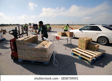 Austin, TX / USA - Nov. 19, 2020: One Week Before Thanksgiving, An Employee Of The Central Texas Food Bank Transfers Disaster Relief  Boxes For Distribution To People In Need.