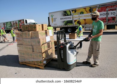 Austin, TX USA - Nov. 19, 2020: One Week Before Thanksgiving, A Male Volunteer For The Central Texas Food Bank Transfers Disaster Relief Boxes For Distribution To People In Need.