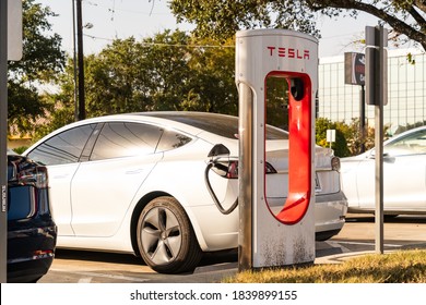 Austin, TX, USA - October 12, 2020: The Tesla Supercharger Station in Central Austin , Texas , USA white tesla model 3 charging at supercharging station