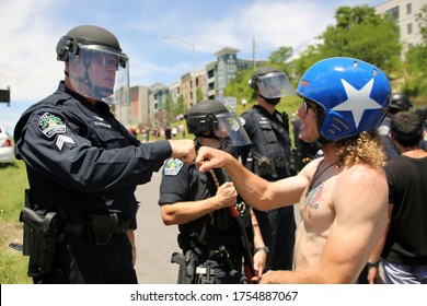 Austin, TX/USA-May 30, 2020:  A male activist protesting the death of George Floyd and Mike Ramos, an African American Hispanic man killed by Austin police in April, bumps fists with a police officer.