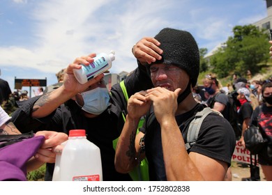 Austin, TX/USA-May 30, 2020: A man protesting the deaths of George Floyd and Mike Ramos, an African-American Hispanic man killed by Austin Police in April, has pepper spray washed from his eyes.  