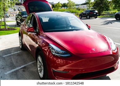 Austin,Texas / USA - June 6th 2020: The Red Hot Electric Car Startup Company Tesla , The Top Seller Electric SUV In A Red Finish Parked On The Sidewalk