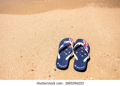 Australia Day and travel destination background: patriotic Aussie thongs featuring Australian flag on the beautiful on the sand