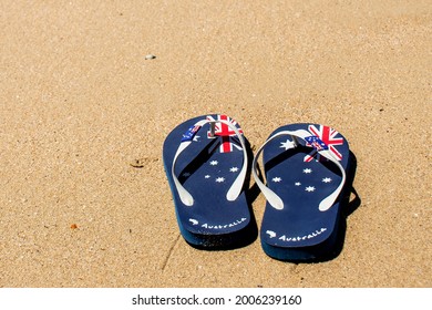 Australia Day and travel destination background: patriotic Aussie thongs featuring Australian flag on the beautiful on the sand