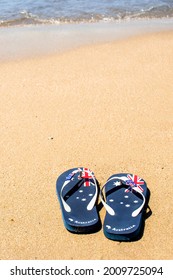 Australia Day and travel destination background: patriotic Aussie thongs featuring Australian flag on the beautiful sandy beach