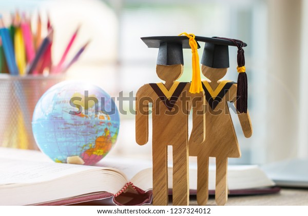 Australia Education knowledge learning study abroad\
international Ideas. People Sign wood with Graduation celebrating\
cap on open textbook with model global map, alternative studying\
world wide