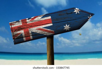 Australia flag wooden sign with a beach on background - Oceania