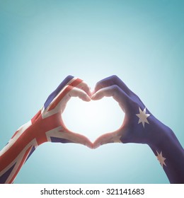 Australia National Flag  On People Hands In Heart Shape Isolated On Sky Background For Labour Day And National Anzac Holiday Celebration



