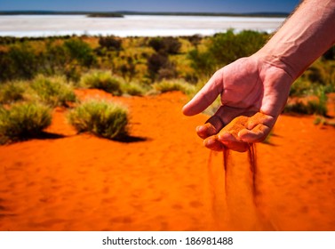 australia outback red sand through hand