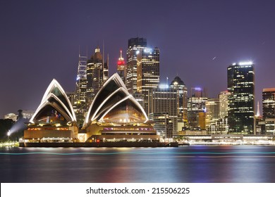 Australia SYdney City CBD close up view over harbour waters at sunset dark sky and reflections of city lights in blurred water