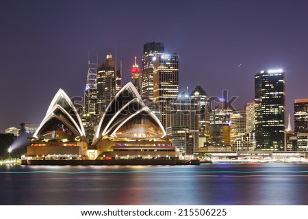 Australia SYdney City CBD close up view over harbour waters at sunset dark sky and reflections of city lights in blurred water