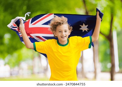 Australia team fans with flag. Australian supporter child. Kid cheering for Aussie football or cricket team victory. Happy little boy with national flag. Patriotic party. - Powered by Shutterstock