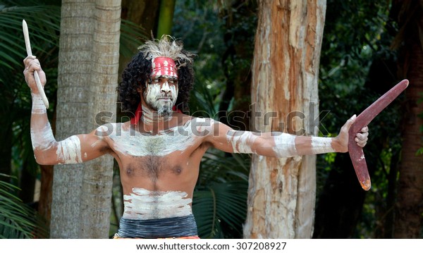 Australian Aboriginal adult man\
throwing boomerang in the tropical far north of Queensland,\
Australia.