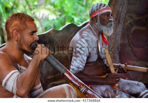 Australian Aboriginal men play Aboriginal music on\
didgeridoo and wooden instrument during Aboriginal culture show in\
Queensland, Australia.\
