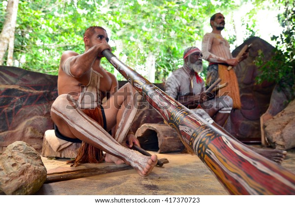 Australian Aboriginal men play Aboriginal\
music on didgeridoo and wooden instrument during Aboriginal culture\
show in Queensland,\
Australia.