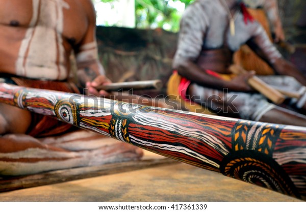 Australian Aboriginal men playing  Aboriginal
music on didgeridoo and wooden instrument during Aboriginal culture
show in Queensland,
Australia.