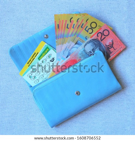 Australian bank notes, driver licence, medicare and coffee stamp cards in blue purse