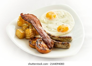 petit-déjeuner australien avec oeufs au plat, saucisses, bacon et pommes de terre sur fond blanc