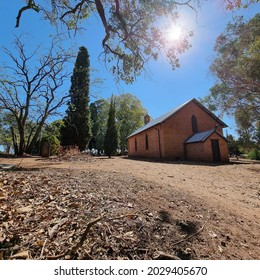 Australian Church Building, High Noon Sun And Undergrowth Beneath The Trees. 