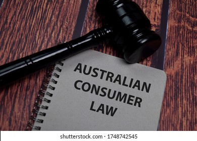 La ley australiana del consumidor escribe sobre papeles aislados en una mesa de madera.