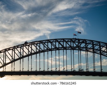 Australian Flag Waves In The Wind Above The Sydney Harbour Bridge.