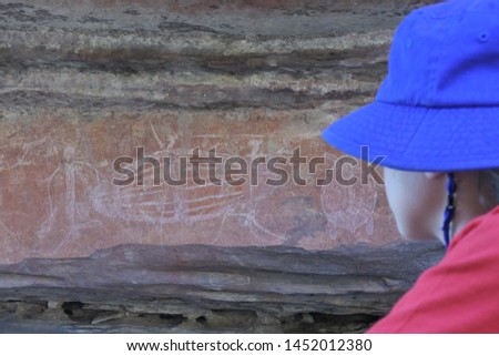 Australian girl tourist (female age 8-9) visit at Ubirr rock art site in Kakadu National Park Northern Territory of Australia. Real people. Copy space