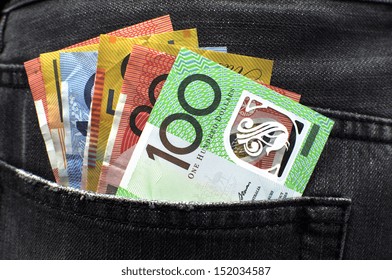 Australian money including 100, 50, 5, 10 and 20 dollar notes, in back pocket of a man's black charcoal jeans pocket.