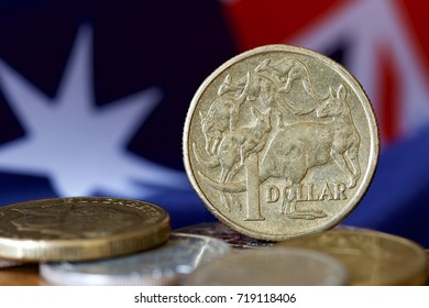Australian one dollar coin with an Australian flag in the background.