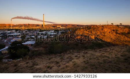 Australian Outback View from the lookout at Mt Isa, Queensland, Australia. Sunrise View of the Copper Mines with smoke coming out of a tower. June, 2019