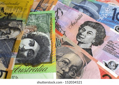 Australian paper money, including one hundred, twenty, ten, five and fifty dollar notes against a black background.